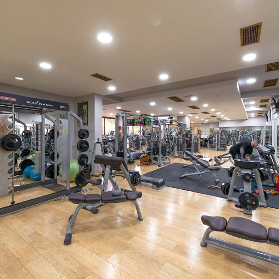Interior view of hotel gym containing dumbbells and barbells