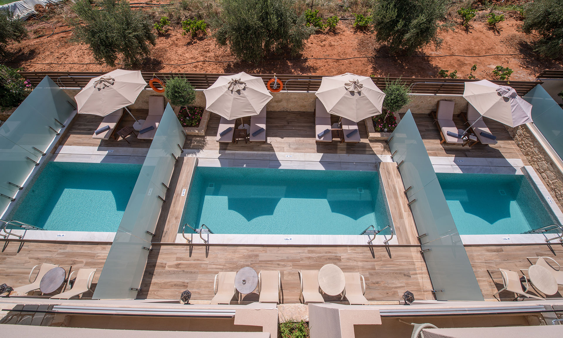 Όψη με τρείς πισίνες μαζί με σετ ξαπλώστρες