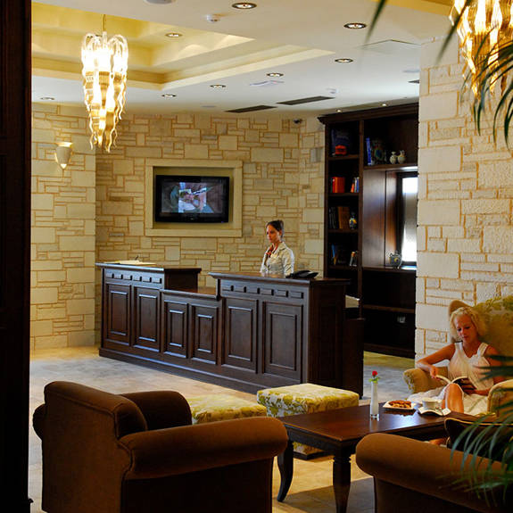 Hotel reception with wooden stand and stone wall