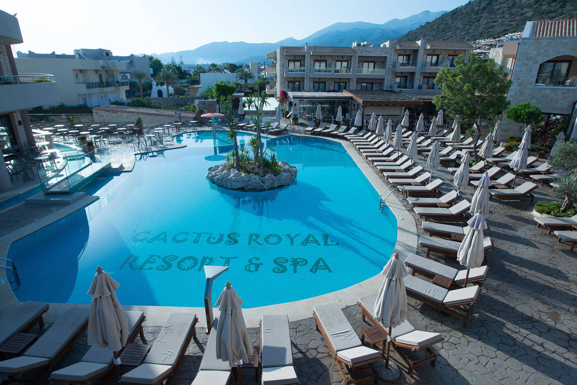 Hotels' main swimming pool, with small islet in the middle and sunbeds