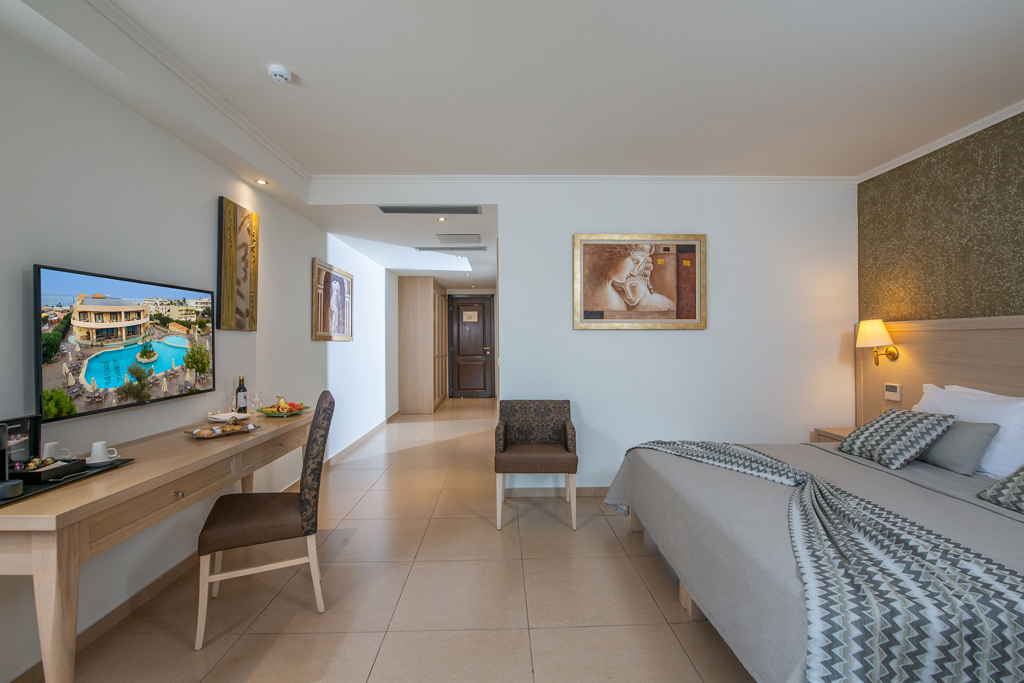 Hotel room with white color with table chairs TV clock and with green wallpaper